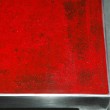 Particolare tavolo alto 120X120 cm. Struttura in acciaio e piano in resina decorato rosso.